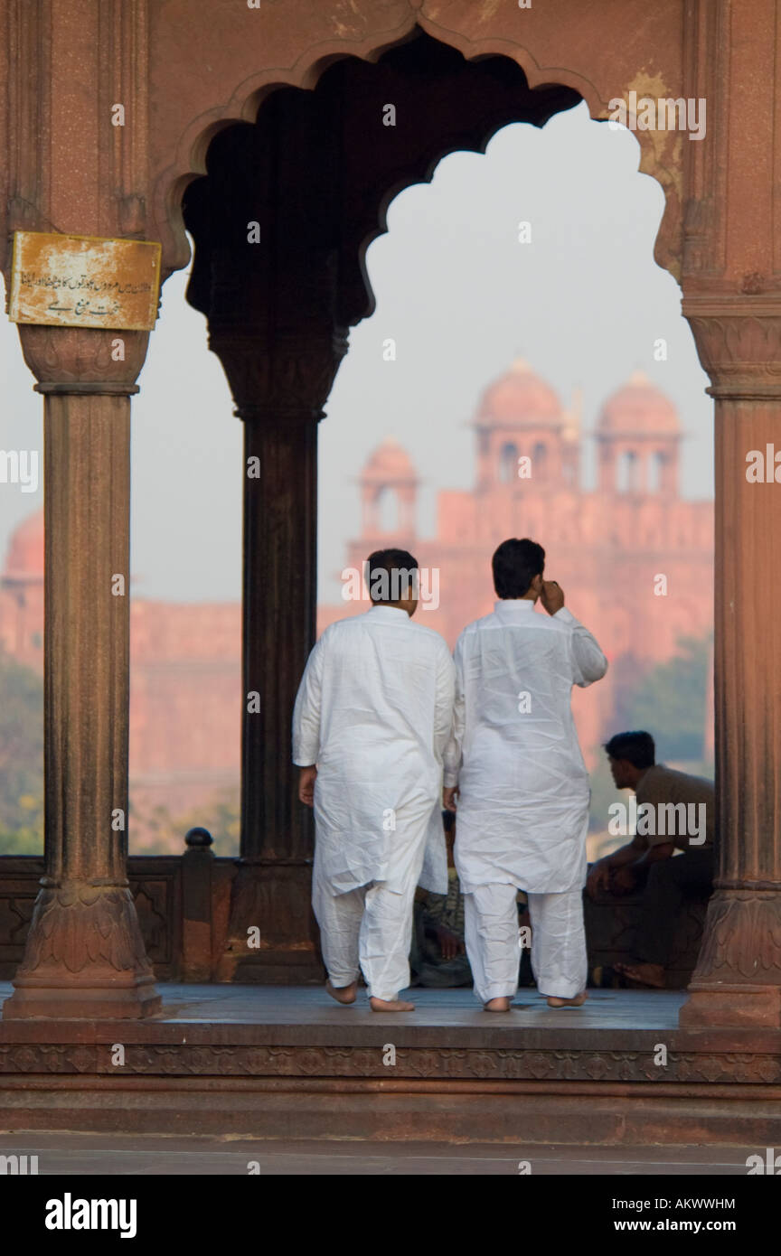 Two Muslim men walk across the terrace of the Jama Masjid Mosque in Old Delhi, India. - Stock Image