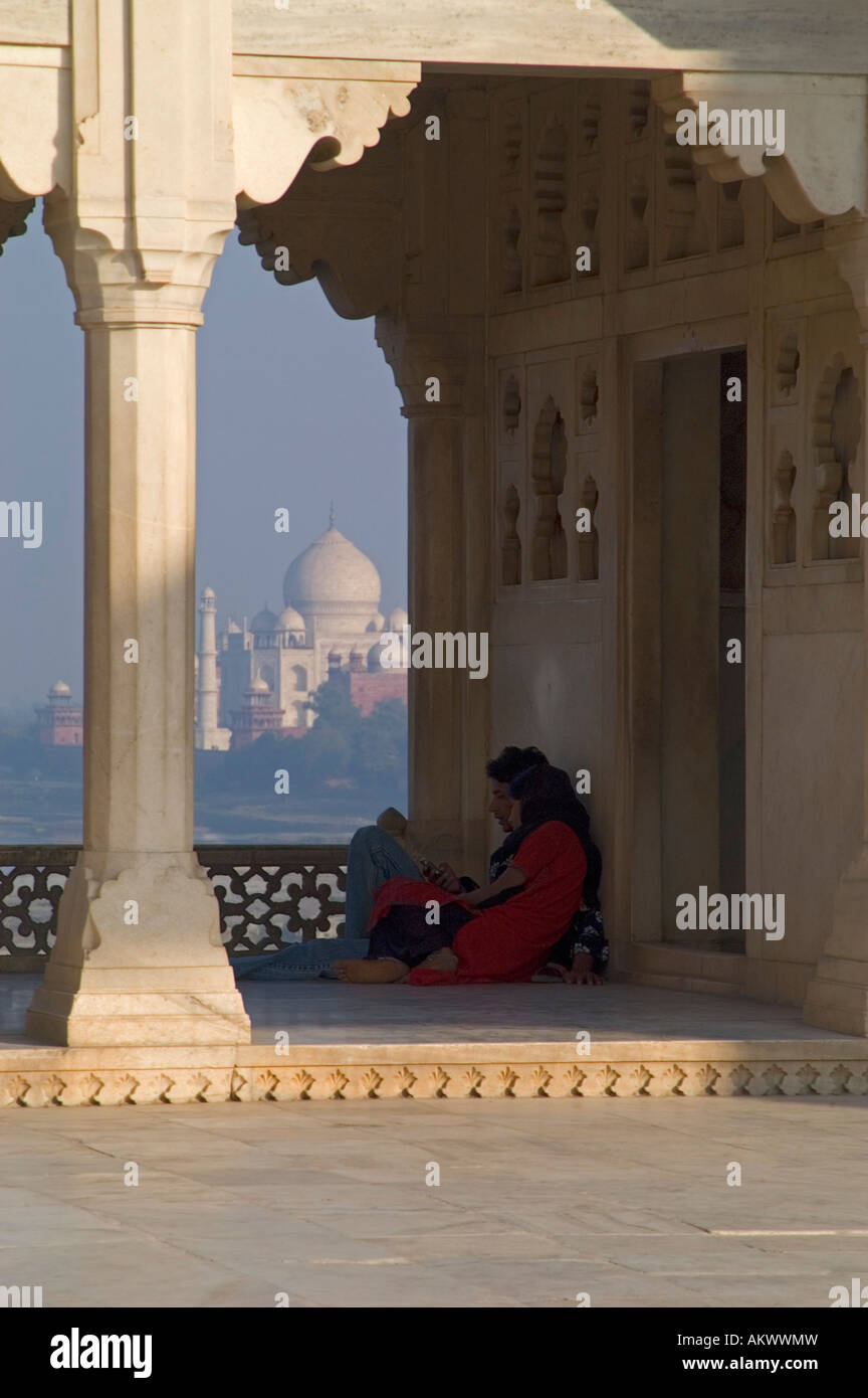 The Taj Mahal rises out of the plains of Uttar Pradesh behind a young couple, as viewed from Agra's Red Fort - Stock Image