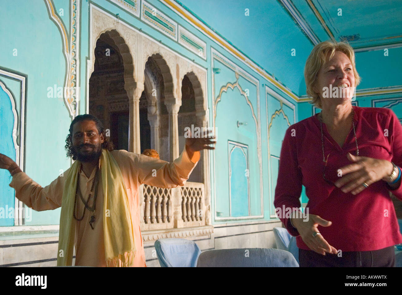 A woman dances to traditional music with a Rajasthani man in Bhadrawati palace in Bhandarej, Rajasthan, India. - Stock Image
