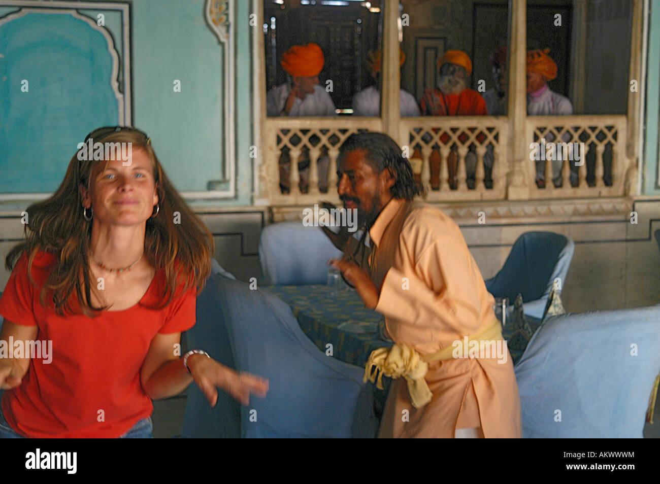 A woman dances to traditional music with a Rajasthani man in Bhadrawati palace in Bhandarej, Rajasthan, India. - Stock Image