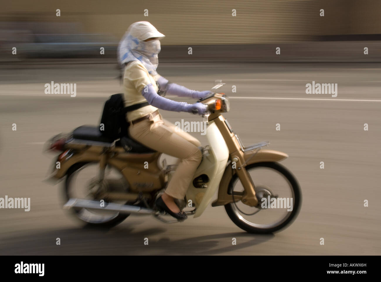 Fashionable young woman on speeding motor bike in Mekong River Delta south of Saigon Stock Photo