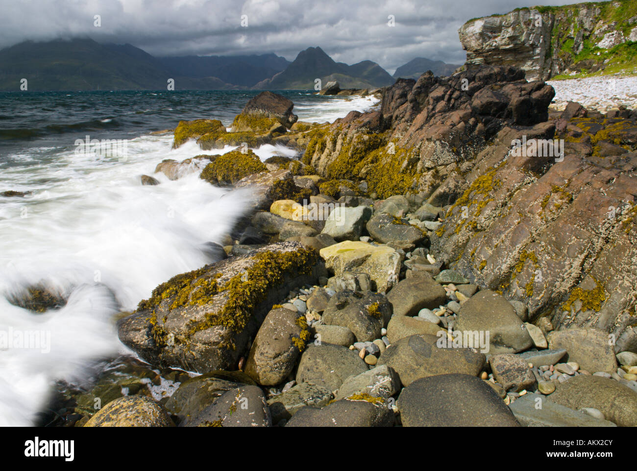 Waves Sea Surf Breaking On The Shoreline Cuillin Mountains In The Distance, Elgol Beach The Isle Of Skye Scotland UK Stock Photo