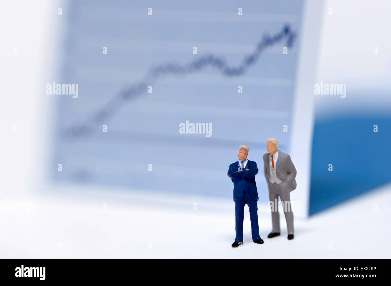 Figurines of businessmen in front of graph Stock Photo