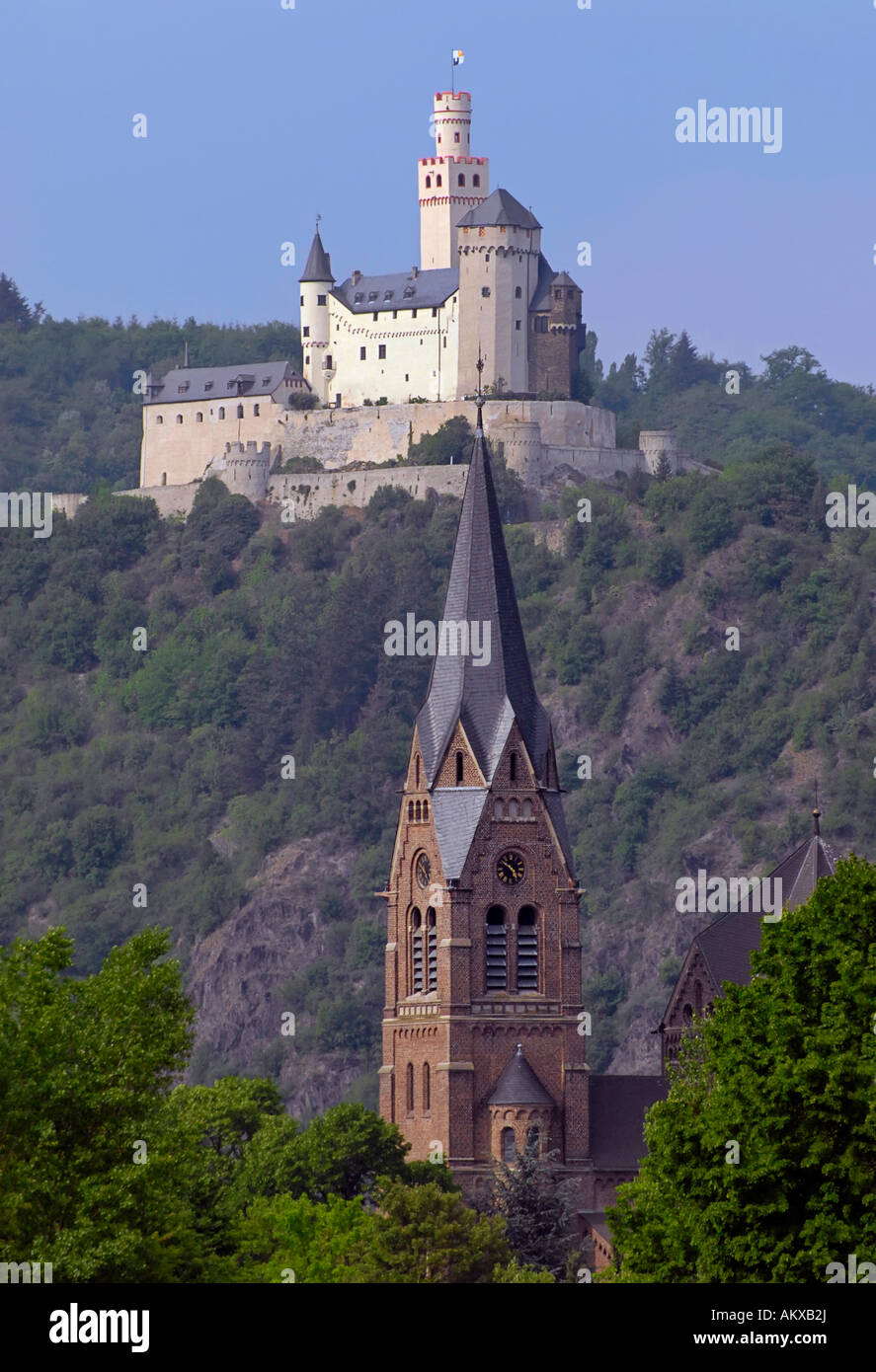 Marksburg, a castle above the town of Braubach with the church St.Lambertus in Spay in the foreground, Middle Rhine, Rhineland- Stock Photo