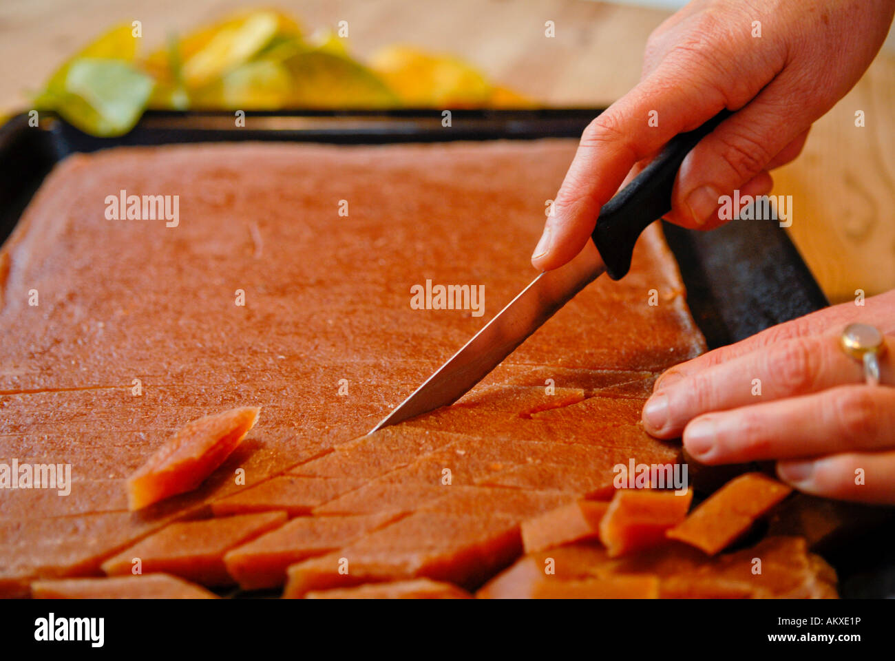 Fresh quince bread being cut by a knife Stock Photo