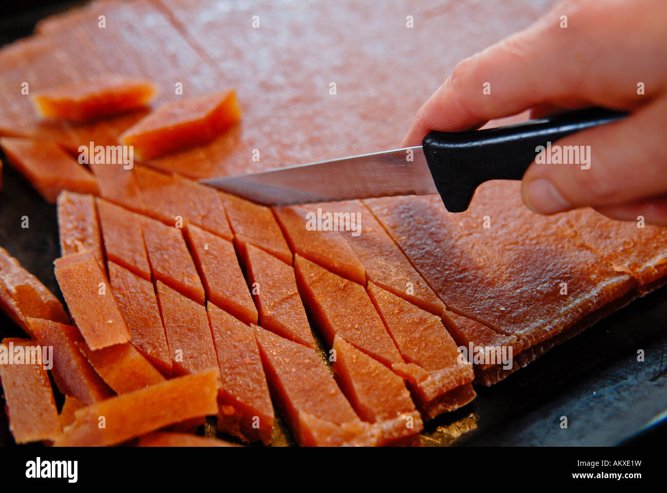 Fresh quince bread being cut by a knife Stock Photo