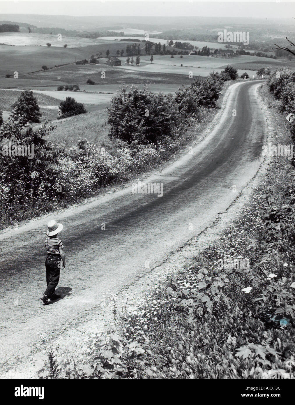 Child walking on long country road 1950 s Stock Photo