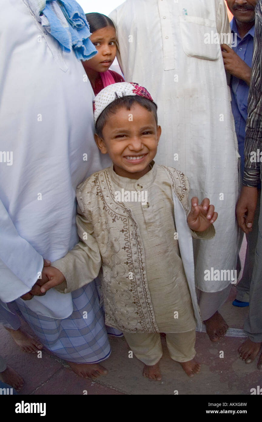 A young Muslim boy stands with his uncles at the Jama Masjid mosque in Old Delhi, India. - Stock Image
