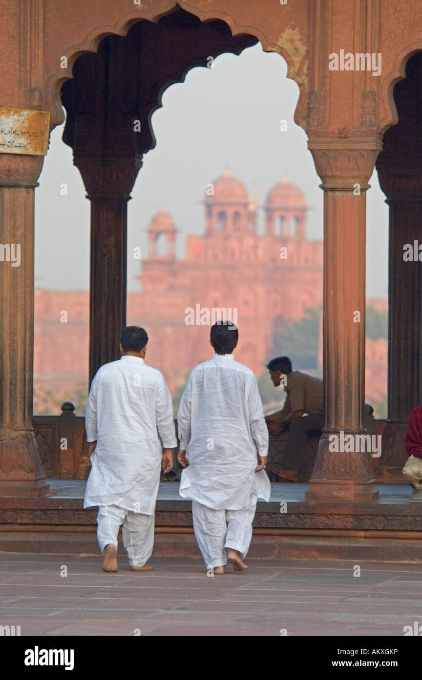 Two Muslim men walk across the terrace of the Jama Masjid Mosque in Old Delhi, India. - Stock Image