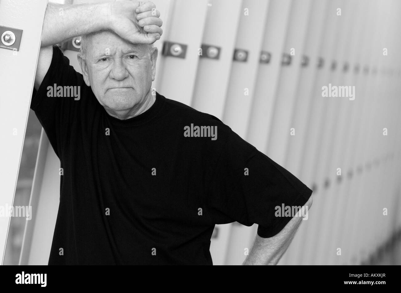 Older man leaning on wall. Stock Photo