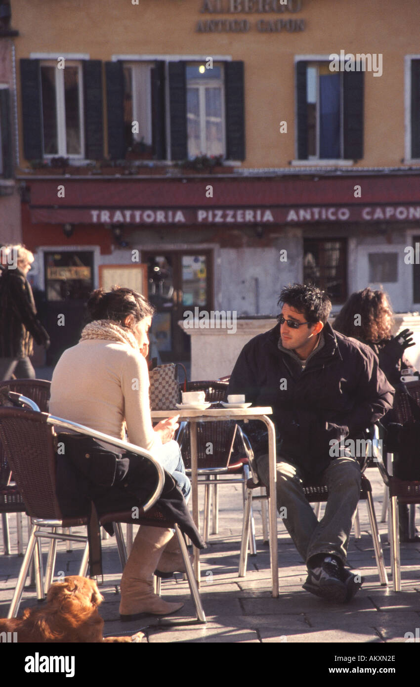 VENICE , ITALY. A young couple enjoying the winter sun on Campo Santa Margherita in Dorsoduro. Stock Photo