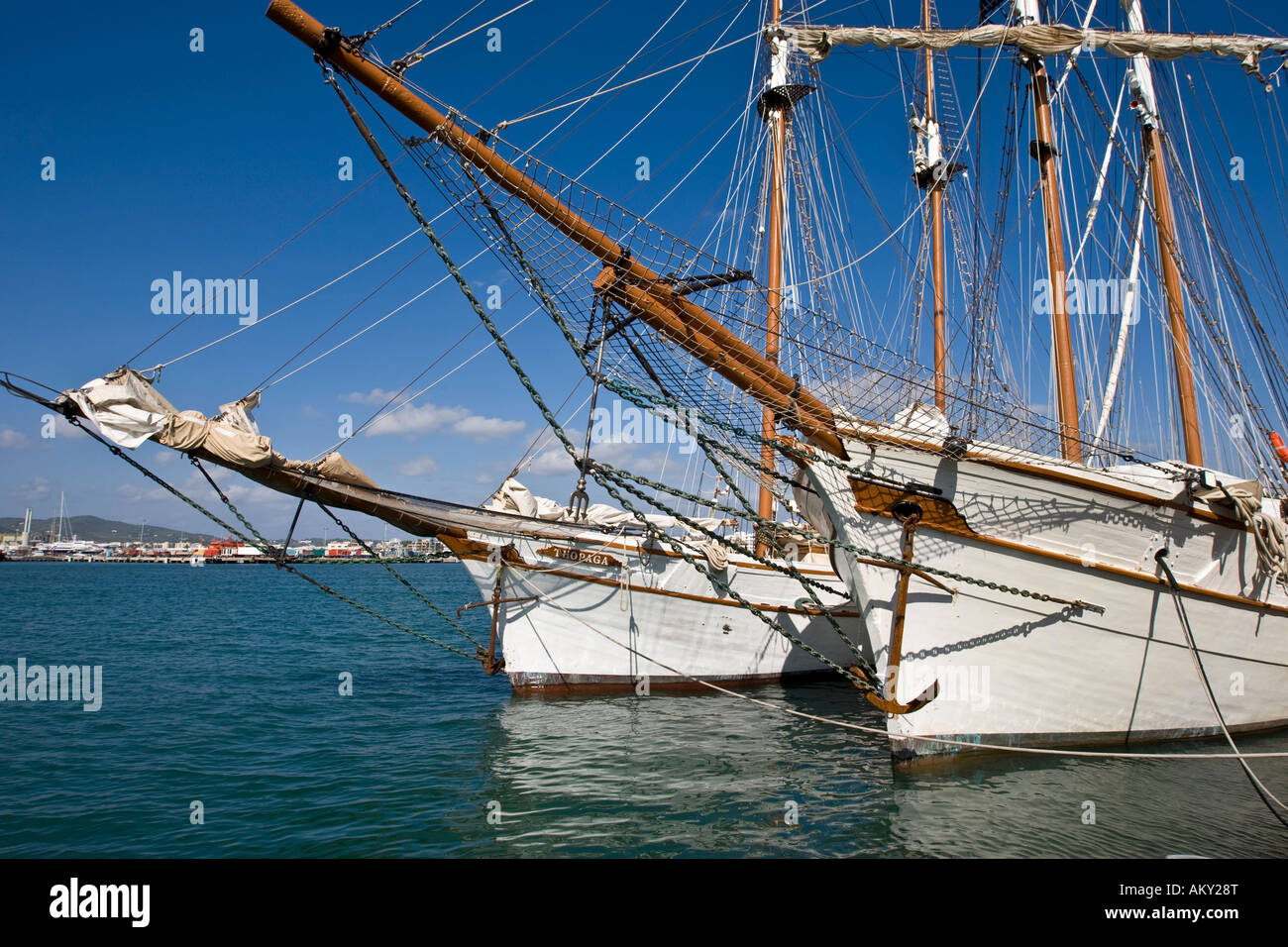 Two historical sailing ships with extensive rigging in the harbour of