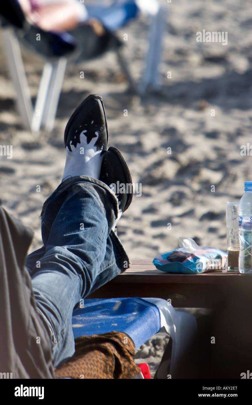Man with Cowboy boots at Les Salinas beach, Ibiza, Balearen, Spanien Stock Photo