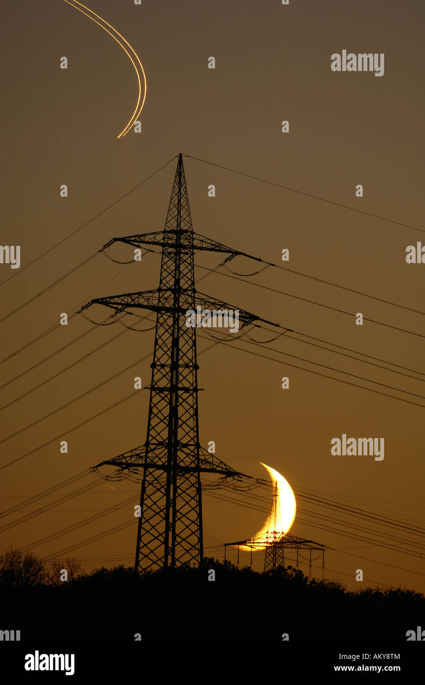 Power poles with moon and airplane tracers Stock Photo