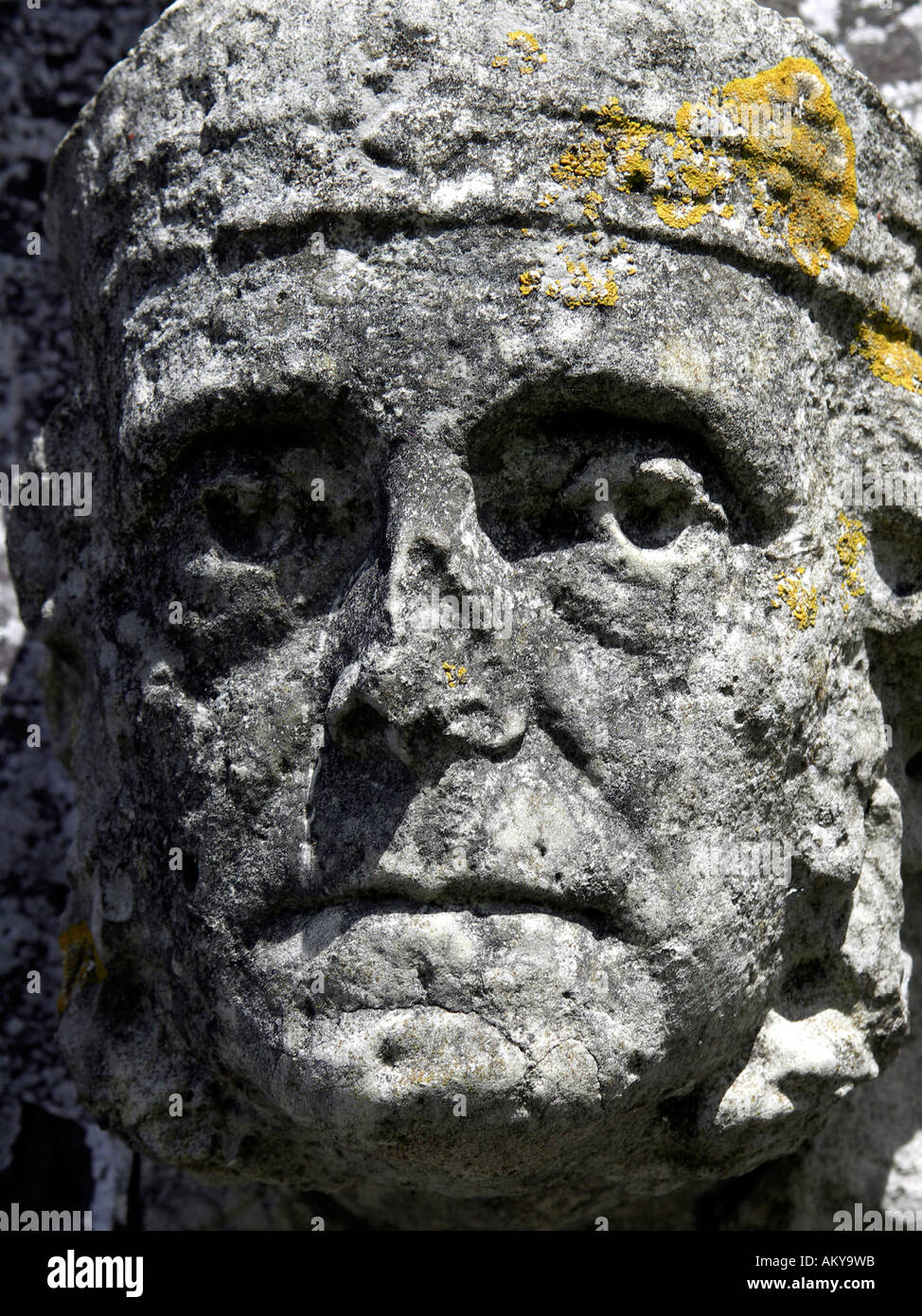 Very old carved stone face with signs of weathering and erosion on the