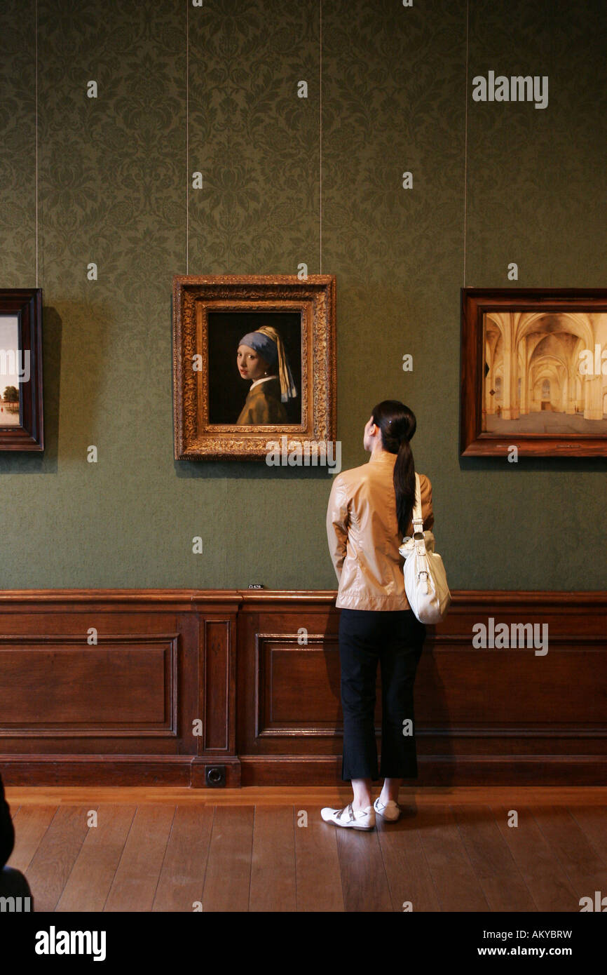 Girl watching the famous painting 'Girl with a Pearl Earring ' by Dutch painter Johannes Vermeer in the museum Mauritshuis in T Stock Photo