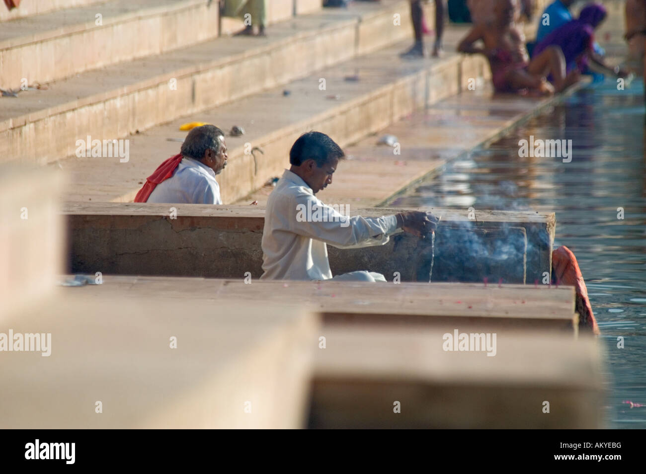 A Hindu pilgrim prays before bathing in the sacred waters of Pushkar Lake at Gangour Ghat, Pushkar, Rajasthan, India. - Stock Image