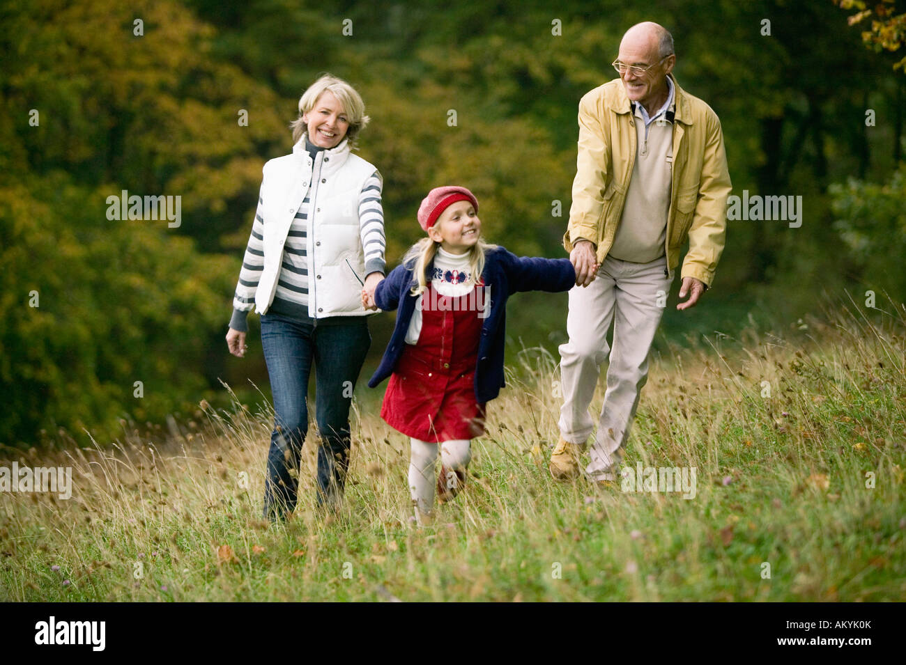 Germany, Baden-Württemberg, Swabby woodian mountains, Grandparents and granddoughter (6-7) walking in forest Stock Photo