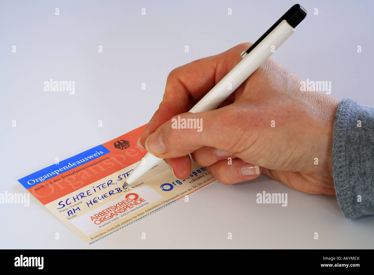 Female hand filling in donor card Stock Photo