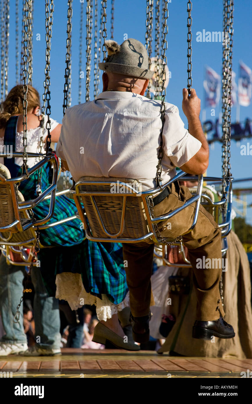 A man in a chairoplane on the Munich Oktoberfes Bavaria Germany. Stock Photo