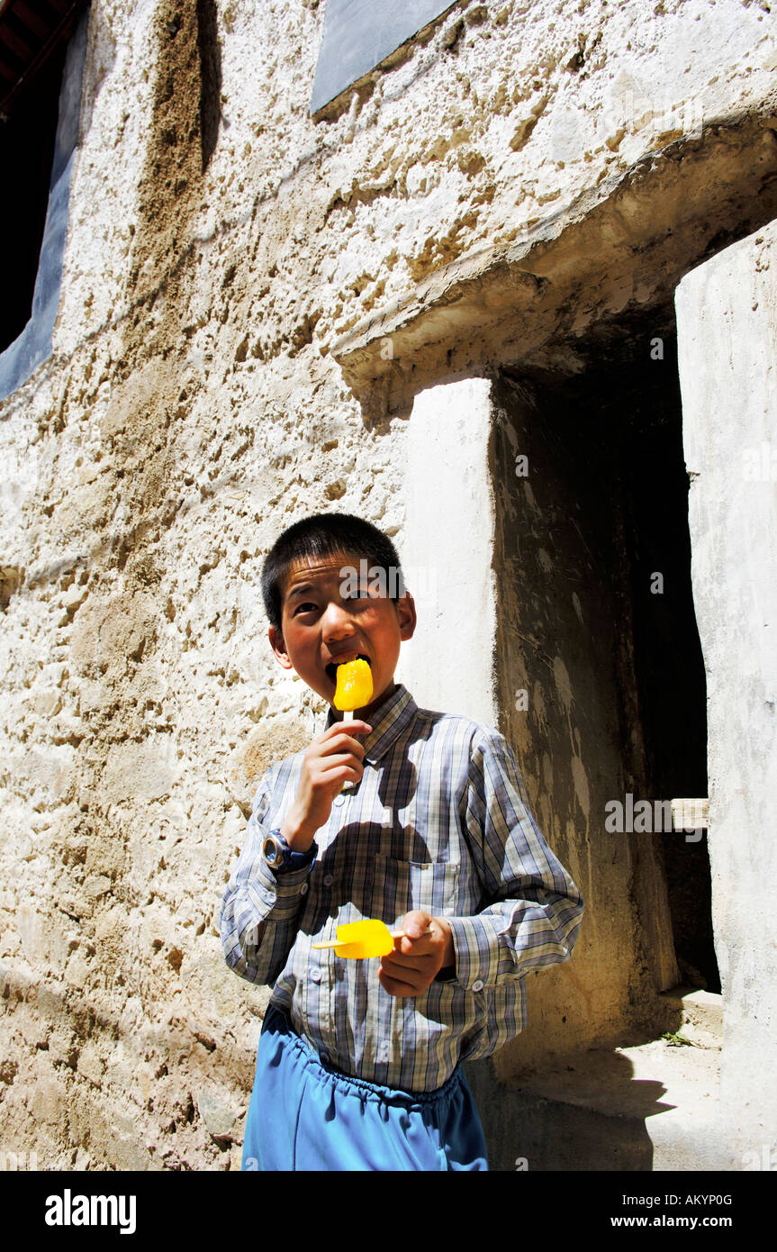 Tibetan boy eats an ice cream, Tibet Stock Photo