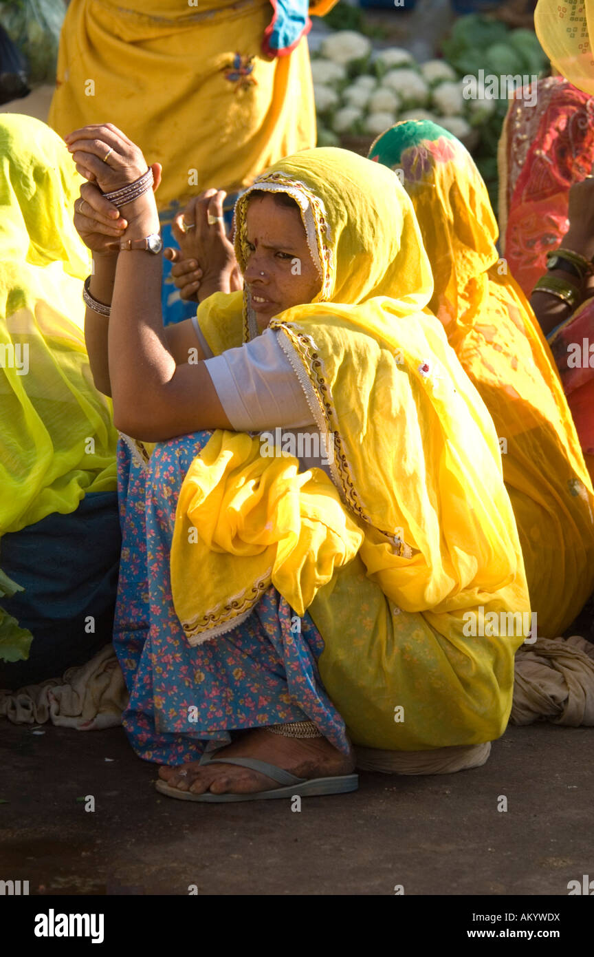 Rajasthani women in bright yellow saris at the market in Pushkar, Rajasthan, India. - Stock Image