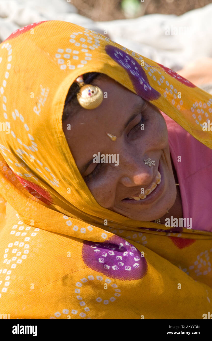 Shanti, a Rajasthani farmer, gazes at her young child in the fields of her hometown of Nimaj, Rajasthan, India. - Stock Image