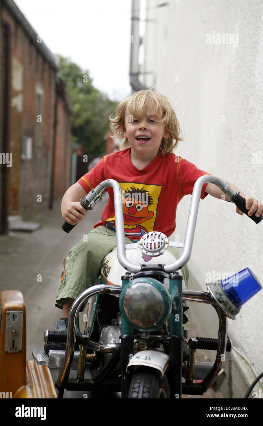 Three-year-old boy on a toy motorcycle Stock Photo