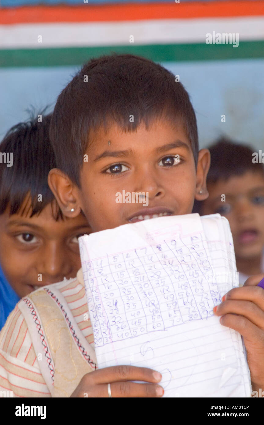 A young Rajasthani boy holds up his math homework in the village government school in Nimaj, Rajasthan, India. - Stock Image