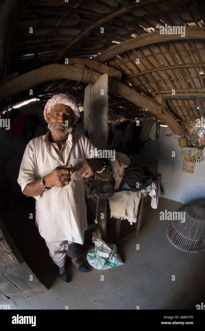 Devi, a semi-retired Rajasthani farmer from the village of Nimaj, Rajasthan, India, spins camel hair into yarn in - Stock Image