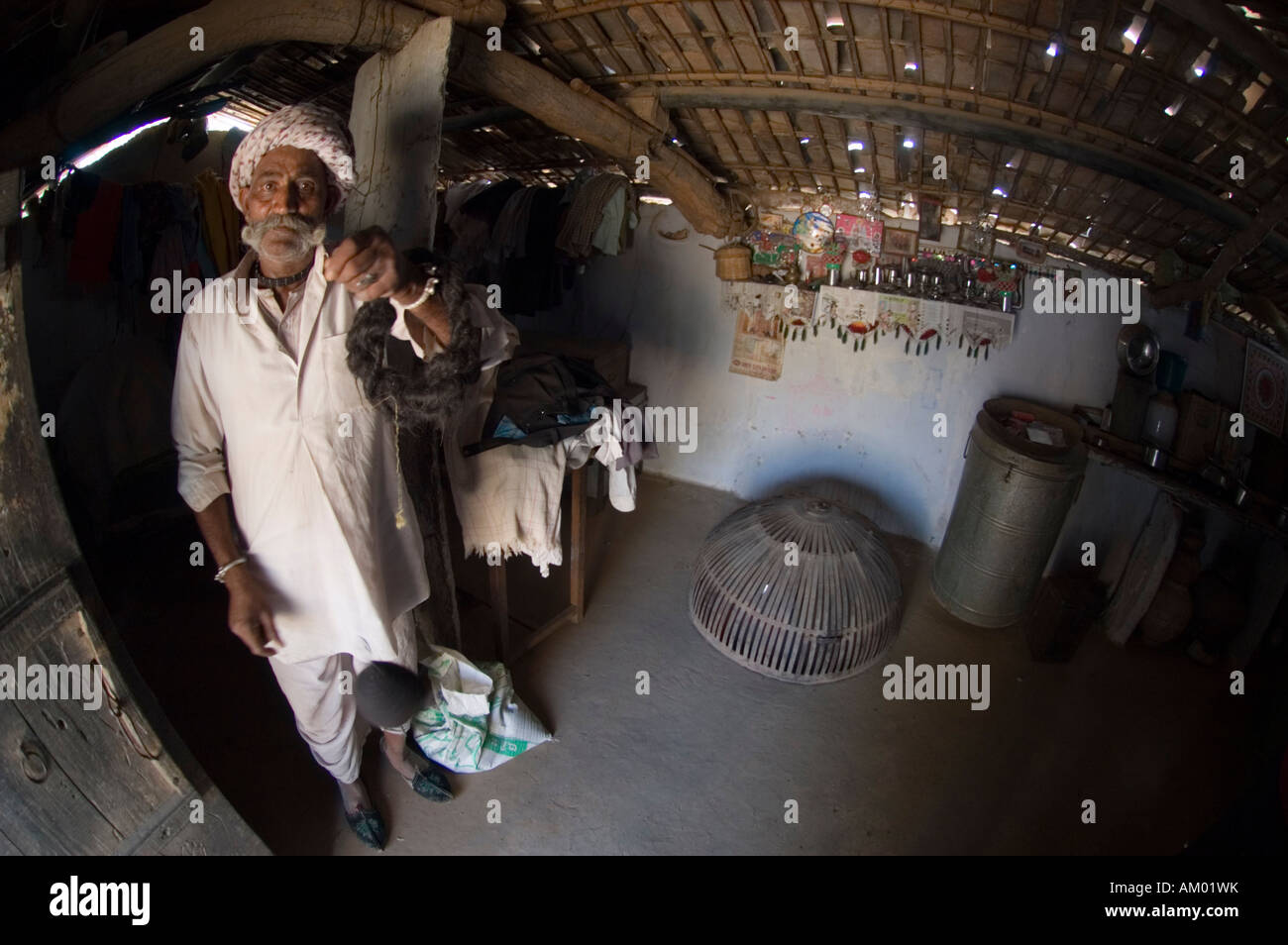 Devi, a semi-retired Rajasthani farmer from the village of Nimaj, Rajasthan, India, spins camel hair into yarn in - Stock Image