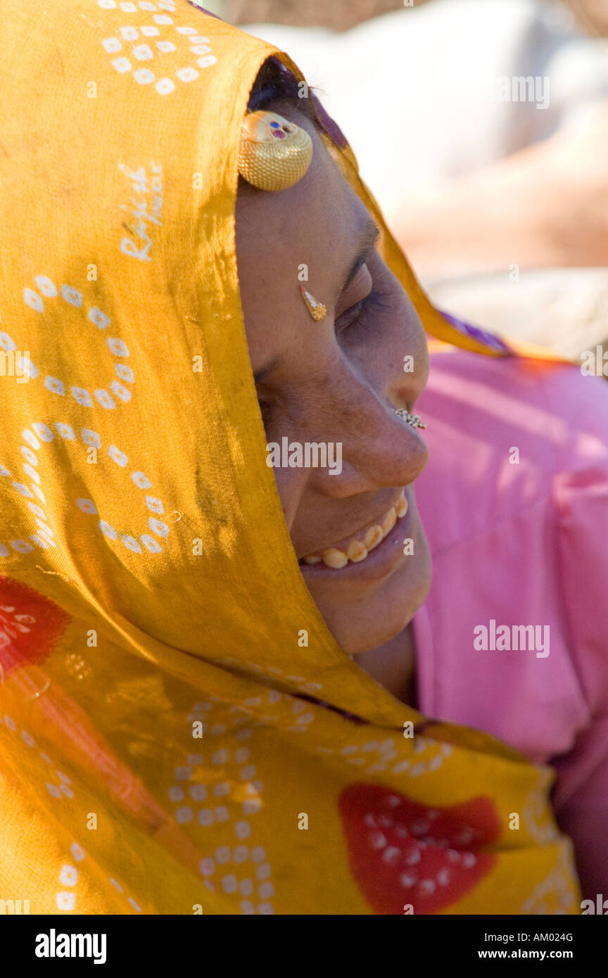 Shanti, a Rajasthani farmer, gazes at her young child in the fields of her hometown of Nimaj, Rajasthan, India. - Stock Image