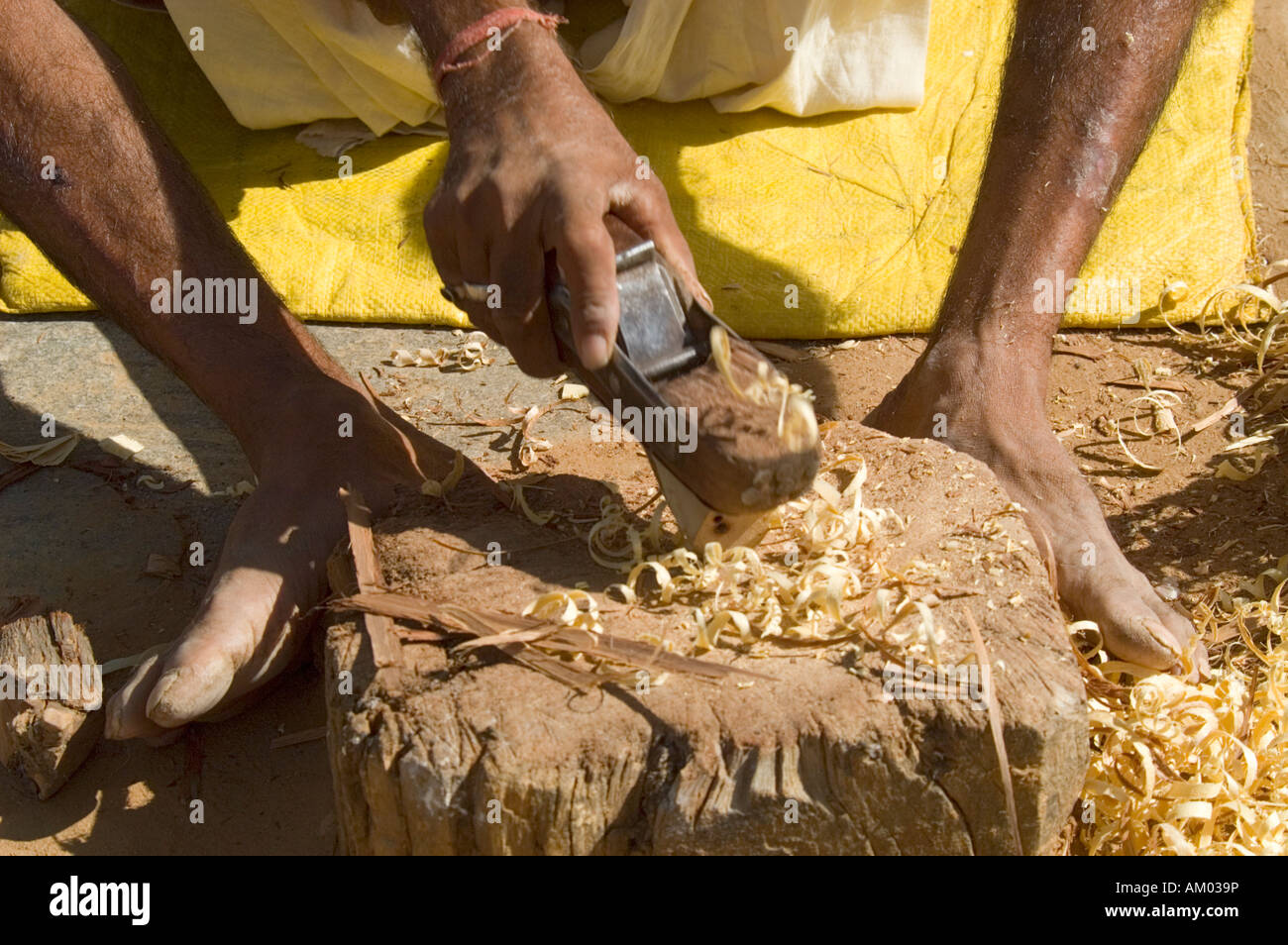 A Rajasthani carpenter planes a cane outside his home in the village of Nimaj, Rajasthan, India. - Stock Image