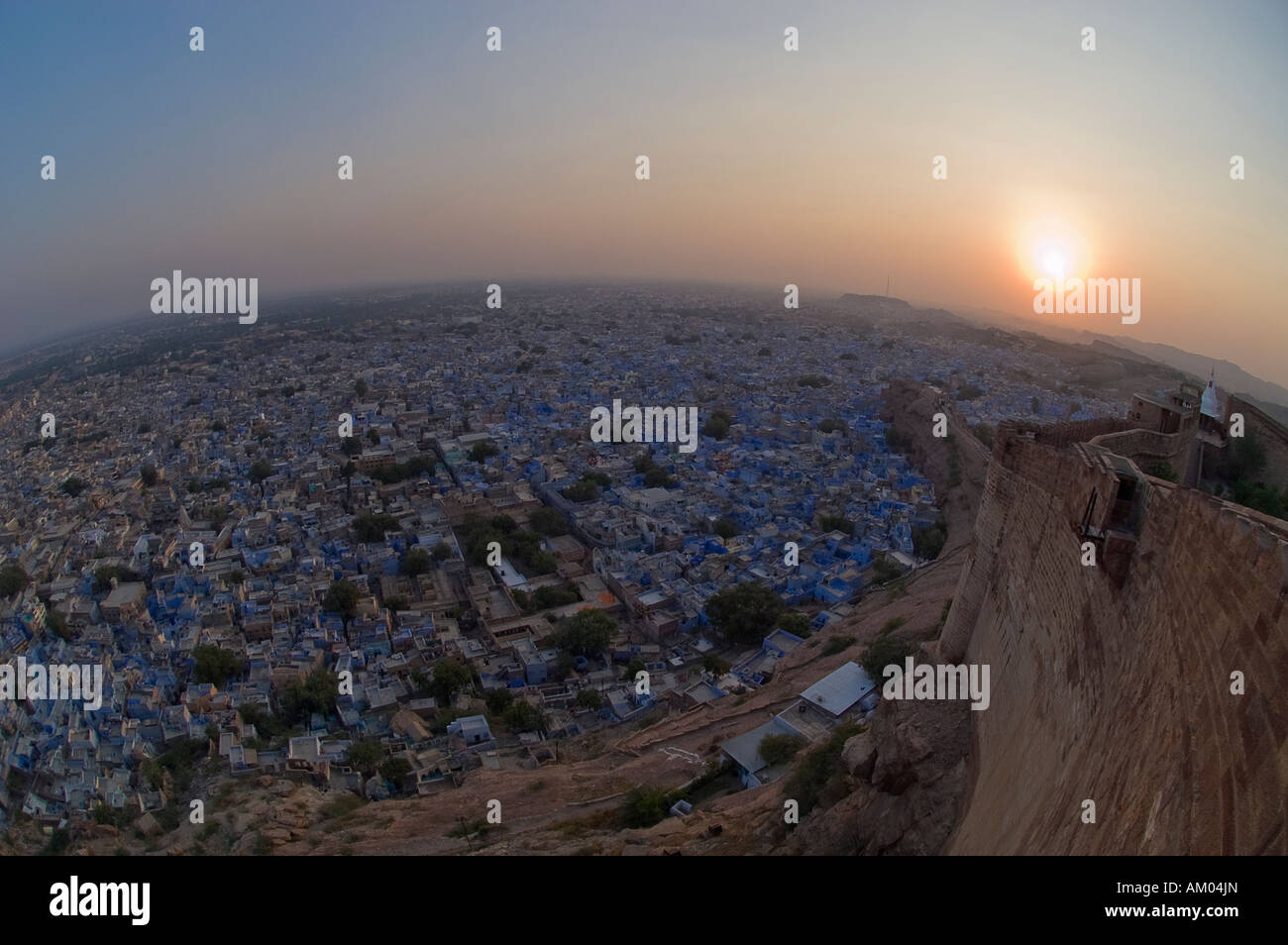 The blue houses of Jodhpur shed an iridescent glow at sunset from the Mehrangharh Fort, Rajasthan, India. - Stock Image