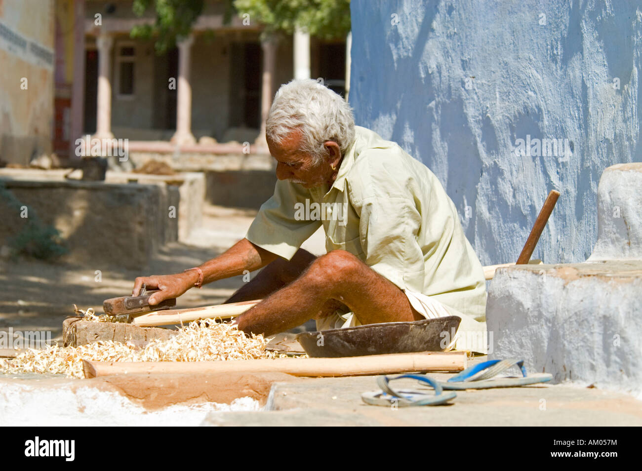 A Rajasthani carpenter planes a cane outside his home in the village of Nimaj, Rajasthan, India. - Stock Image