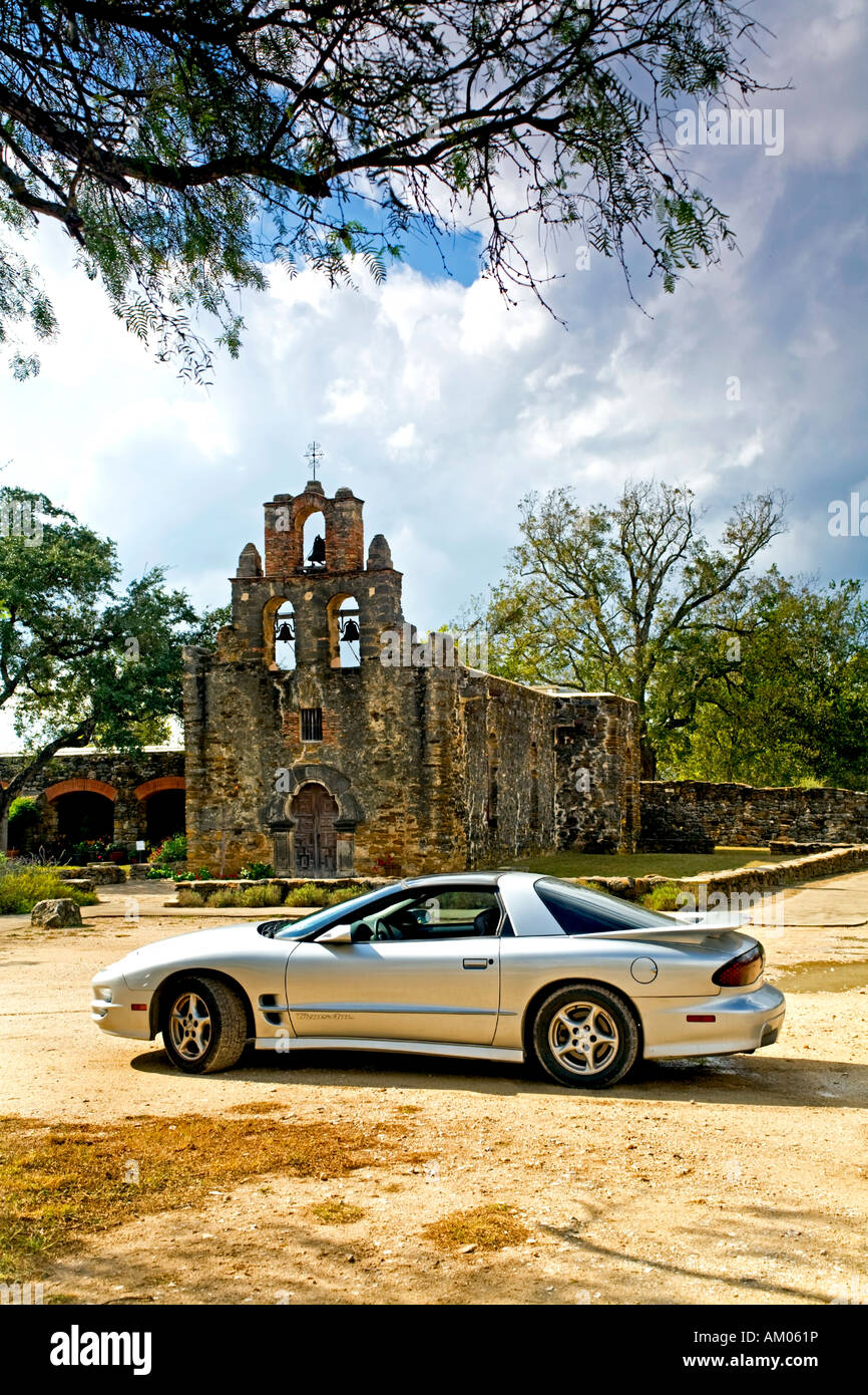 Mission Espada and Trans Am sports car parked in front under tree Stock Photo