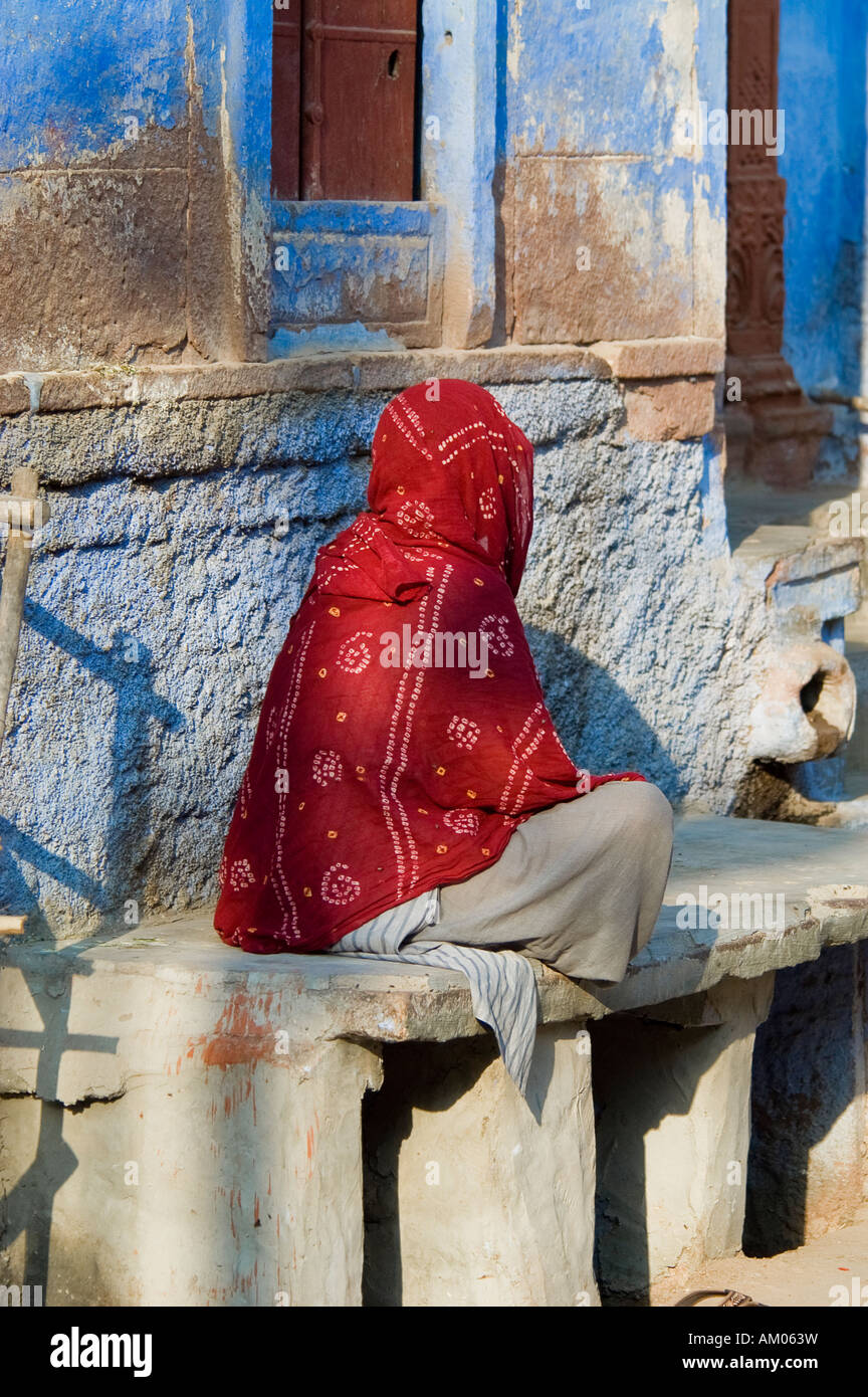 An elderly woman rests in the early morning sun in Jodhpur's Girdikot Market, India. - Stock Image