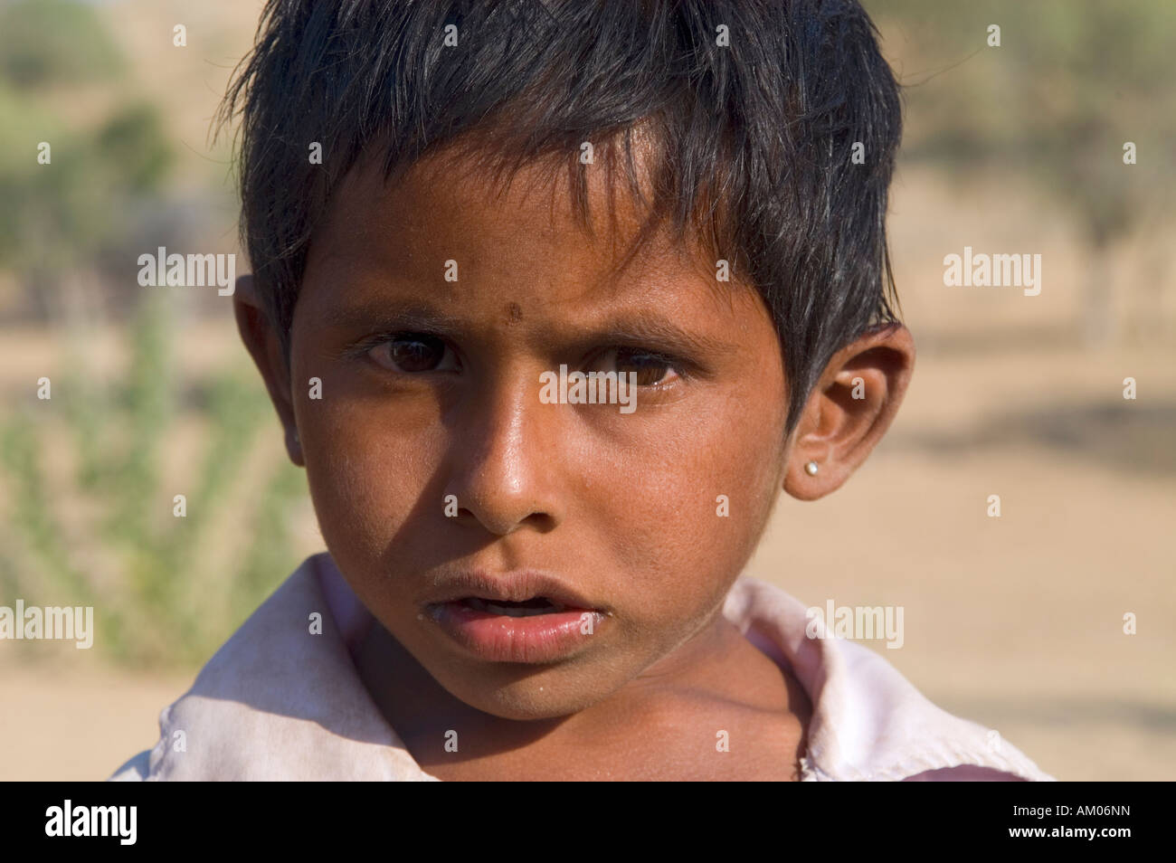 A young boy outside his home in the dunes of the Great Thar Desert near Manvar, Rajasthan, India. - Stock Image