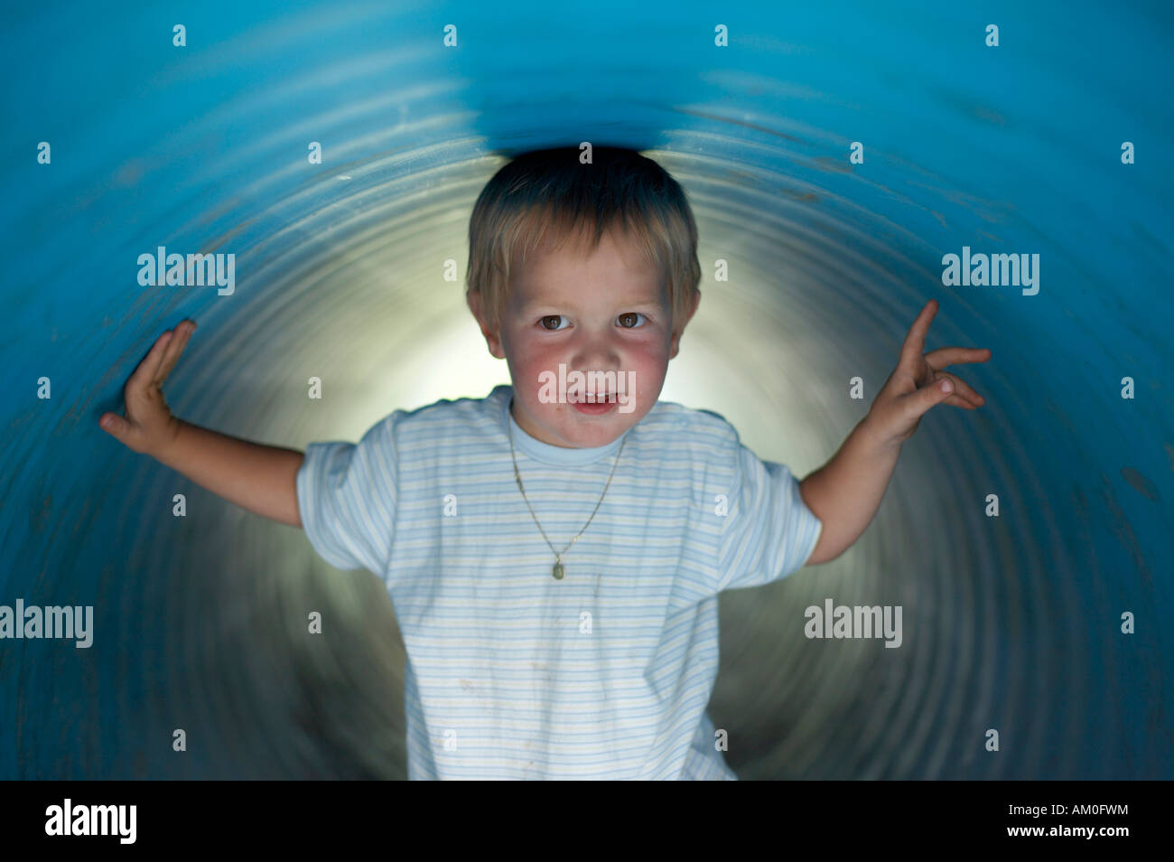 Small boy walks through an underground play tunnel Stock Photo