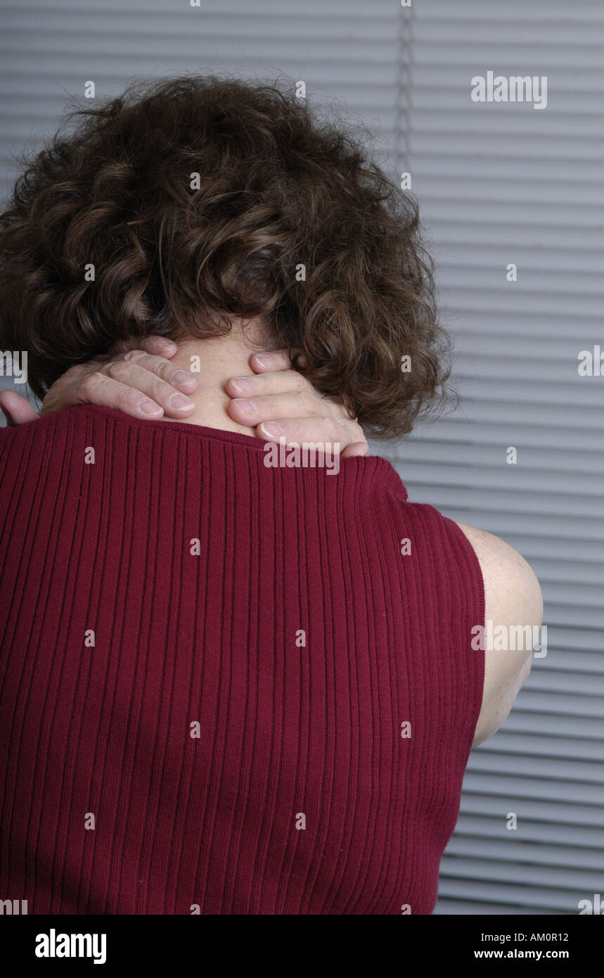 A woman messaging a sore spot on her body. Stock Photo