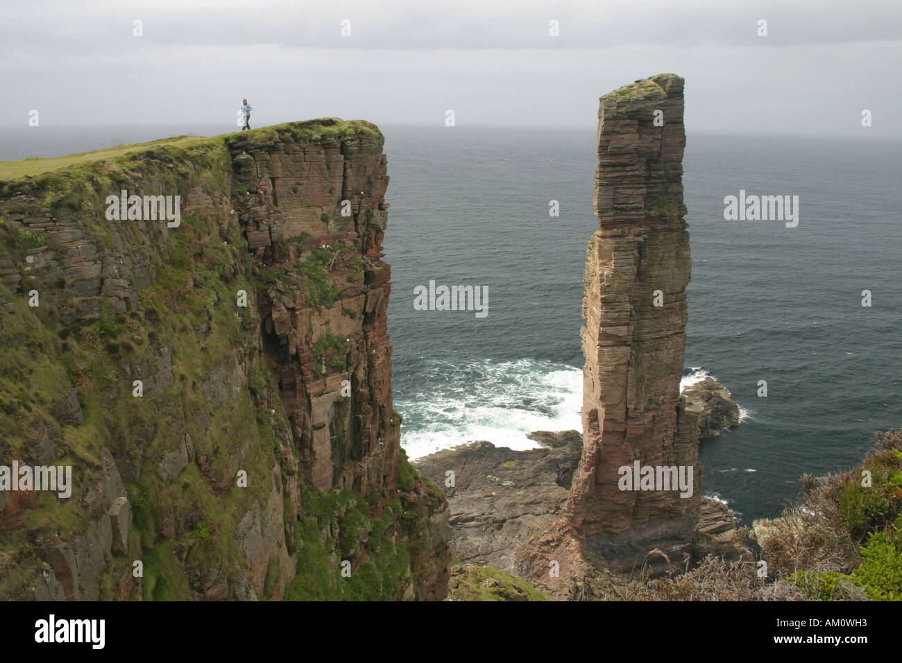 Young woman walking at The Old Man of Hoy, Orkney Stock Photo