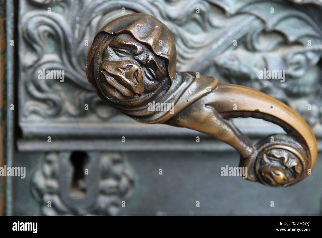 Doorhandle with grimace face and lock at a side portal of the cathedral of Cologne, NRW, Germany Stock Photo
