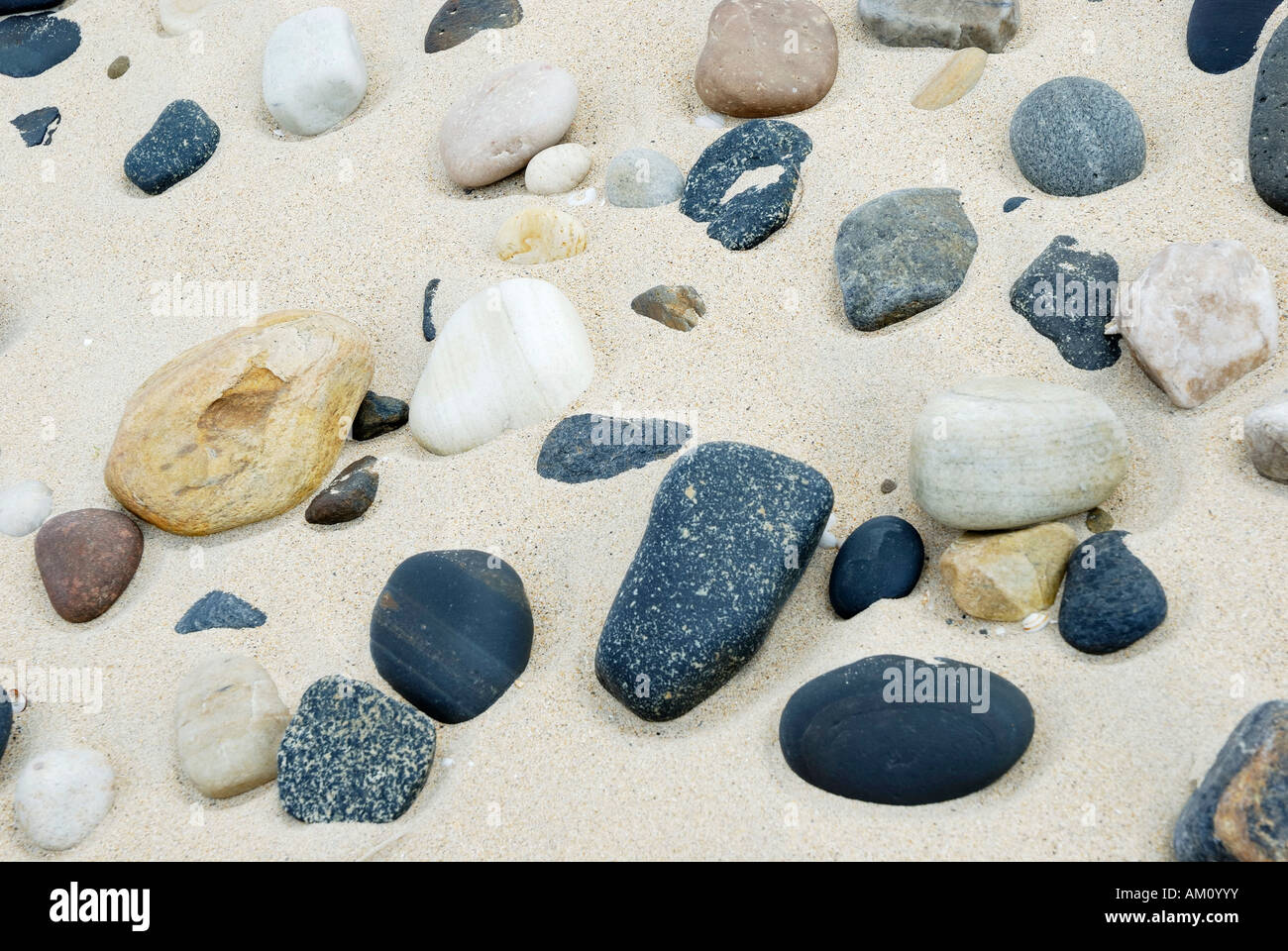 Pollished pebbles of volcanic and sedimentary origine permanently grinded by blowing sand, Ireland Stock Photo
