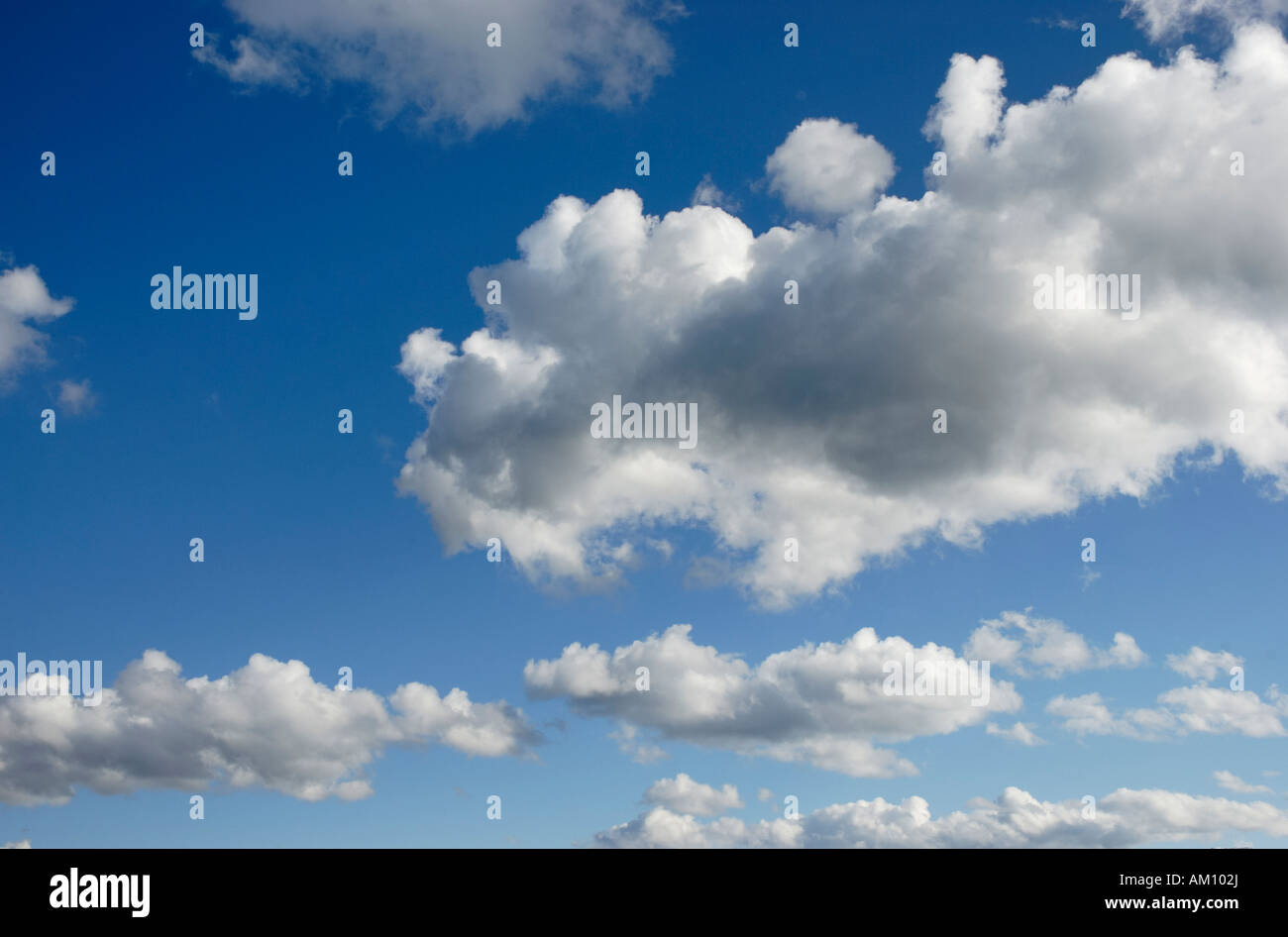 Fast flying cumulus clouds on brilliant bue sky Stock Photo