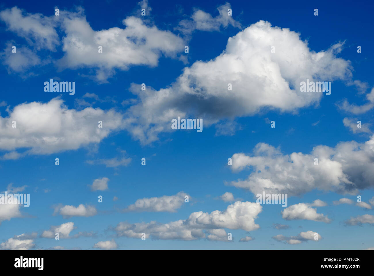 Fast flying cumulus clouds on brilliant bue sky Stock Photo