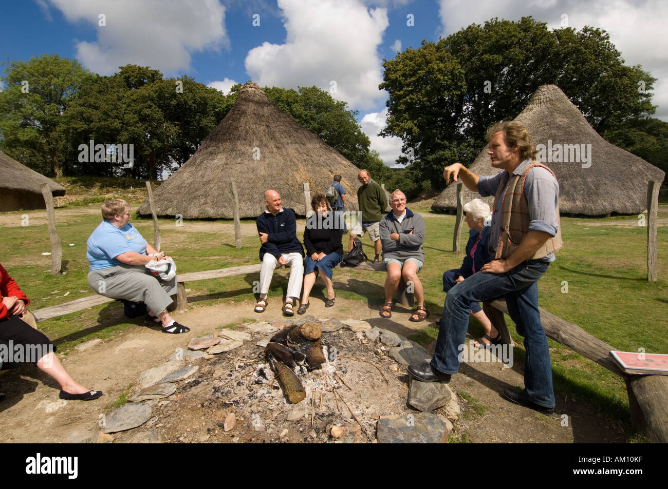 Interpretive guide giving talk about the history of Castell Henllys reconstructed Iron Age hill fort Pembrokeshire wales