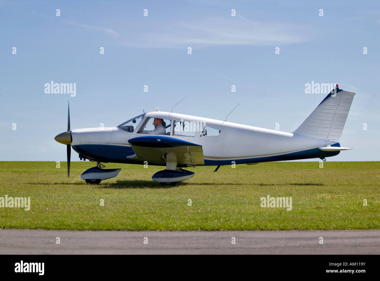 Light aircraft taxiing on a grass runway about to take off Stock Photo