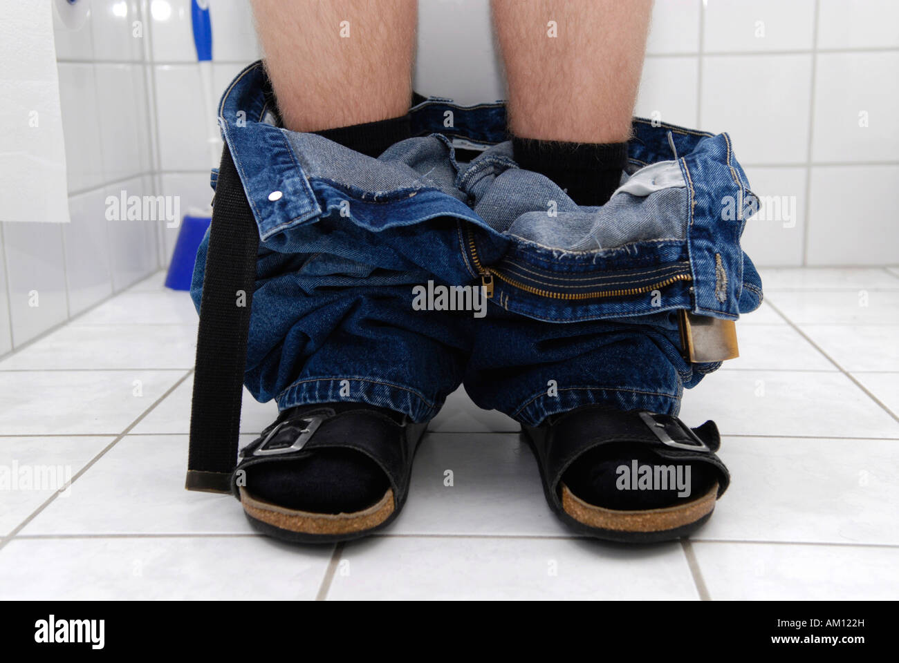 Man sitting on toilet Stock Photo