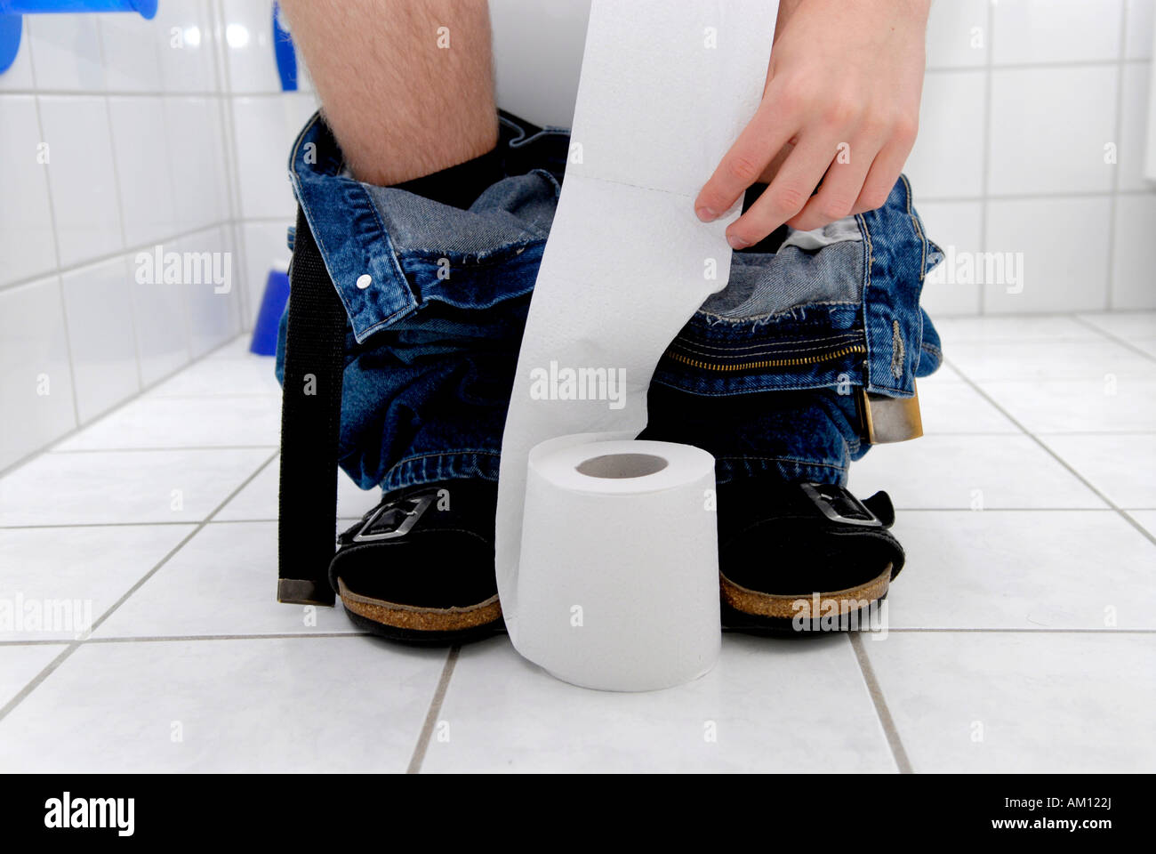 Man sitting on toilet Stock Photo
