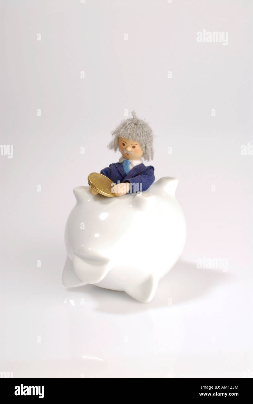 Senior doll with Euro coin sitting in a piggy bank Stock Photo